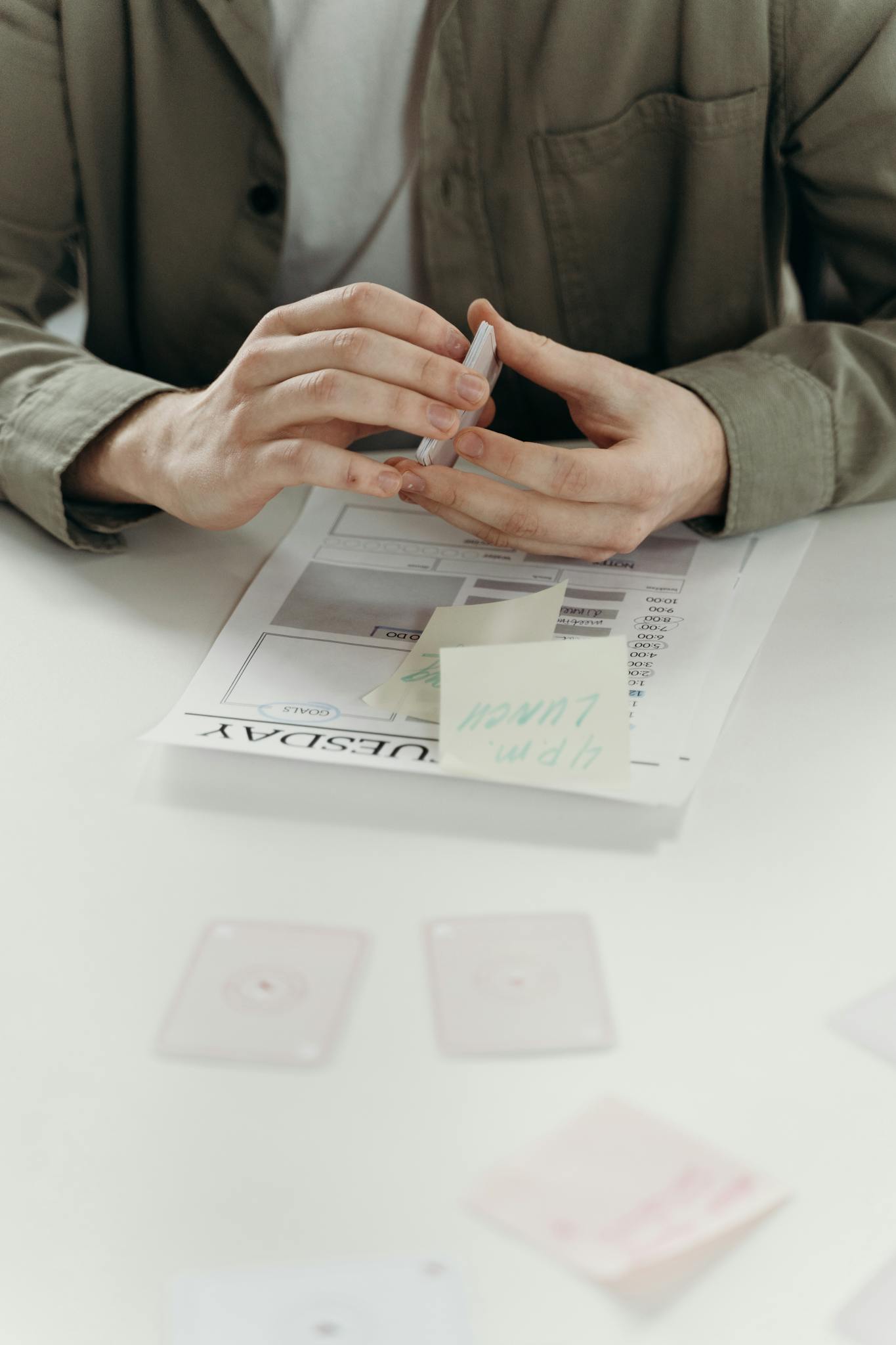 Close-up of hands planning and organizing business strategy with documents and notes.